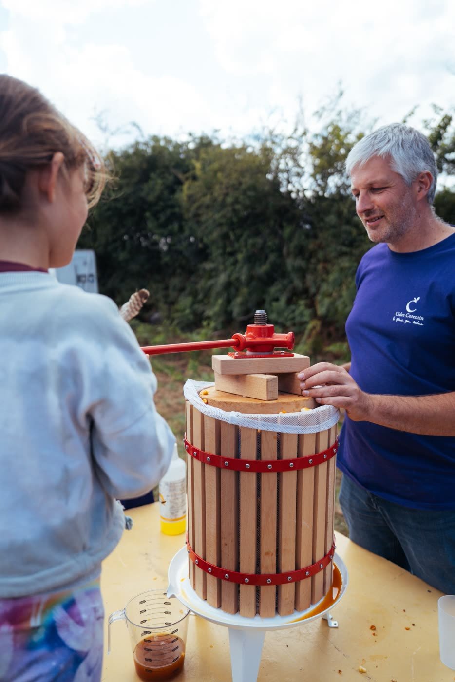 Pressage des pommes avec une jeune visiteuse